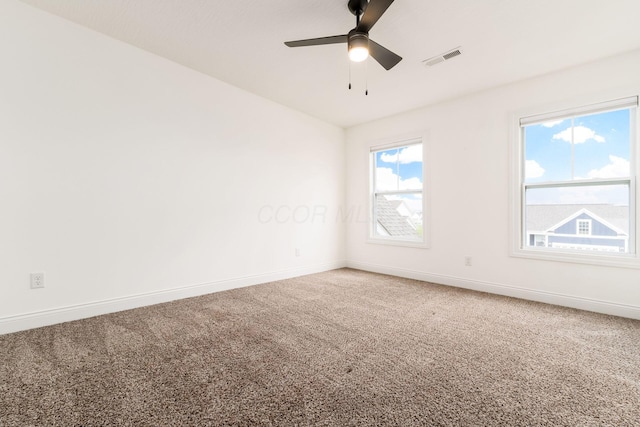 empty room featuring carpet flooring, visible vents, and baseboards