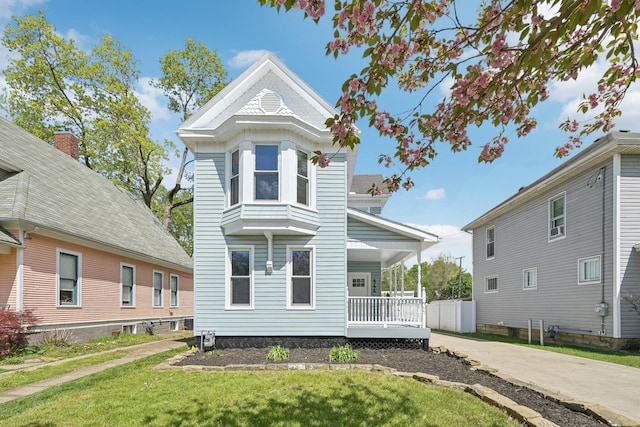 view of front of home with a front yard and covered porch