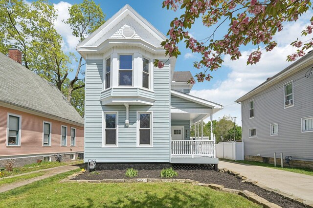 view of front of house featuring covered porch and a front yard
