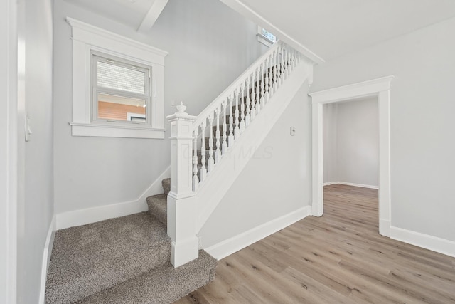 stairway with wood finished floors and baseboards