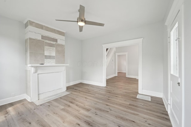 unfurnished living room with baseboards, light wood-type flooring, and ceiling fan