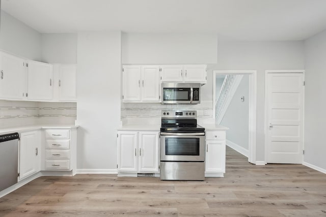 kitchen featuring white cabinetry, backsplash, stainless steel appliances, and light countertops