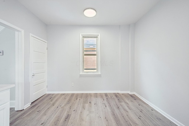 unfurnished room with light wood finished floors and baseboards