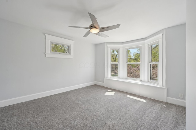 spare room featuring ceiling fan, carpet, and baseboards