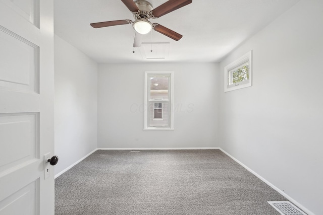 carpeted spare room featuring a ceiling fan and baseboards