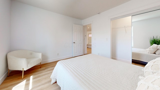 bedroom featuring baseboards, light wood-style floors, and a closet