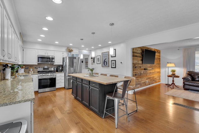 757 State Rte 61, Sunbury, OH 43074 - kitchen with recessed lighting, stainless steel appliances, a breakfast bar area, white cabinetry, and wooden counters