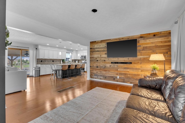 757 State Rte 61, Sunbury, OH 43074 - living area featuring wood walls, ornamental molding, light wood-type flooring, and recessed lighting