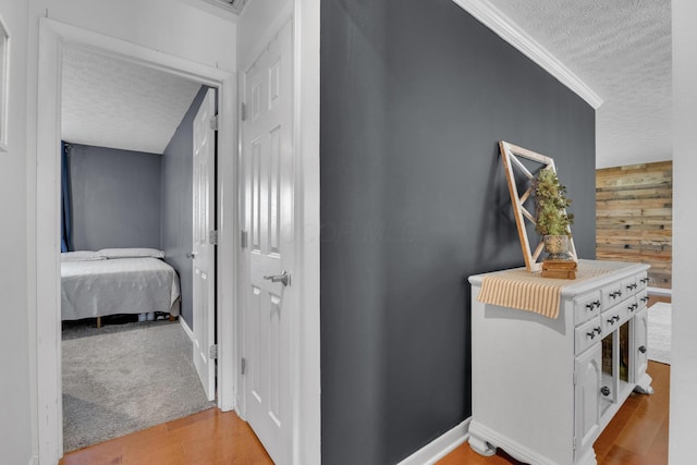 757 State Rte 61, Sunbury, OH 43074 - hallway with wood walls, a textured ceiling, crown molding, and light wood-style flooring