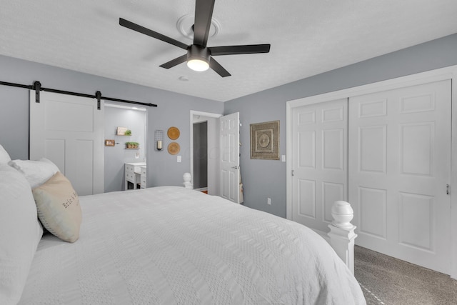 757 State Rte 61, Sunbury, OH 43074 - bedroom featuring carpet floors, a barn door, a closet, a ceiling fan, and a textured ceiling