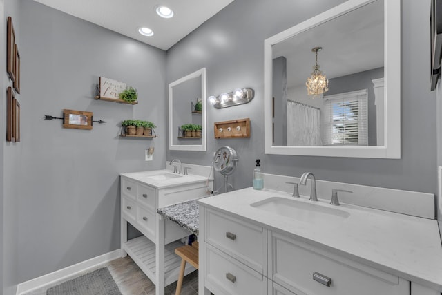 757 State Rte 61, Sunbury, OH 43074 - full bathroom with baseboards, two vanities, a notable chandelier, and a sink