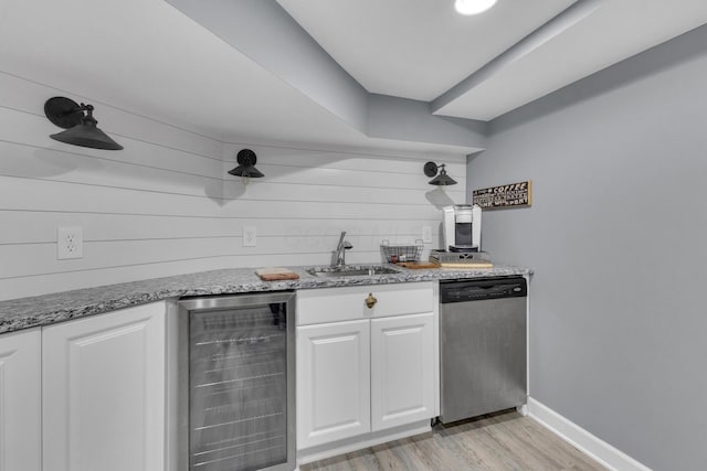 757 State Rte 61, Sunbury, OH 43074 - kitchen featuring stainless steel dishwasher, light wood finished floors, a sink, white cabinetry, and wine cooler