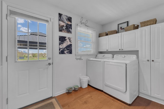 757 State Rte 61, Sunbury, OH 43074 - laundry room featuring light wood-style flooring, a healthy amount of sunlight, cabinet space, and washing machine and dryer