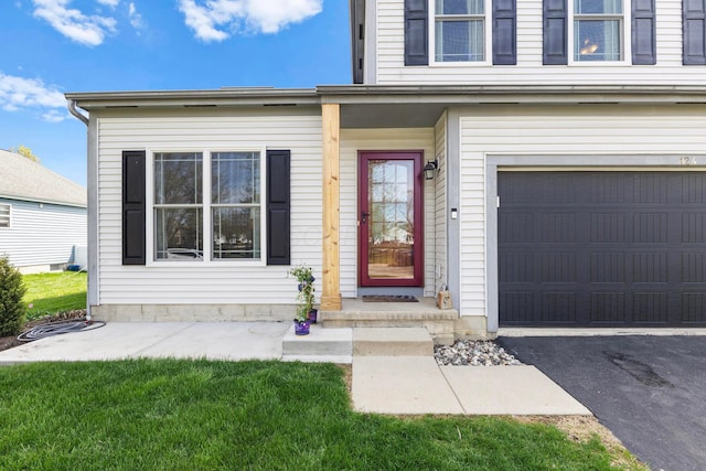 view of exterior entry with a garage and driveway