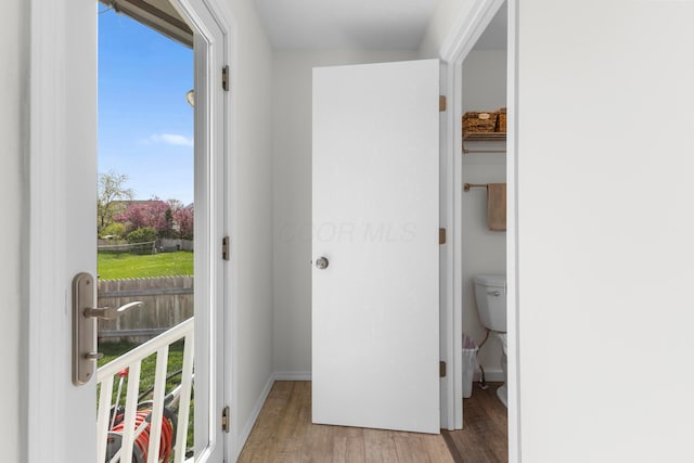 doorway to outside featuring baseboards and wood finished floors