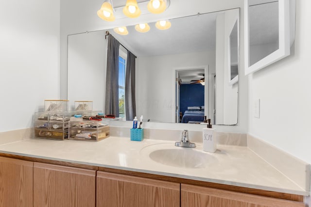 ensuite bathroom with vanity, connected bathroom, and ceiling fan