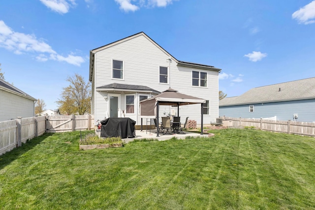 rear view of house with a gazebo, a fenced backyard, a lawn, and a patio