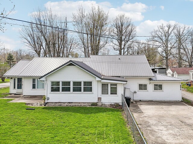 8870 College St, Lakeview, OH 43331 - rear view of house with metal roof, a yard, and concrete driveway