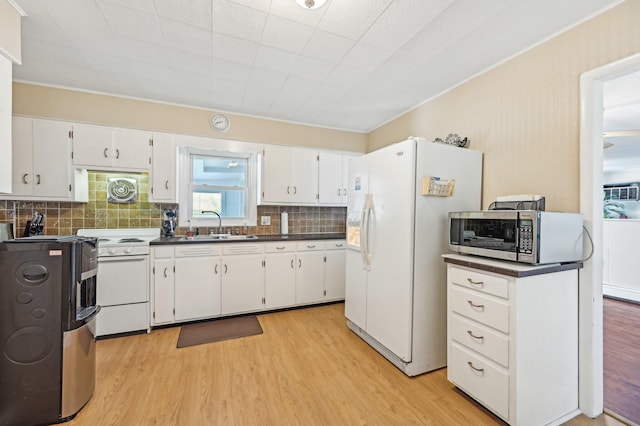 8870 College St, Lakeview, OH 43331 - kitchen with a sink, tasteful backsplash, dark countertops, light wood-style floors, and white appliances