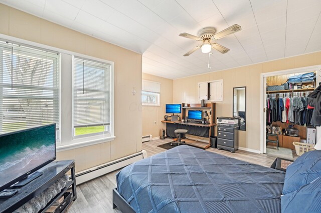 8870 College St, Lakeview, OH 43331 - bedroom with baseboard heating, light wood-style floors, a spacious closet, and a closet