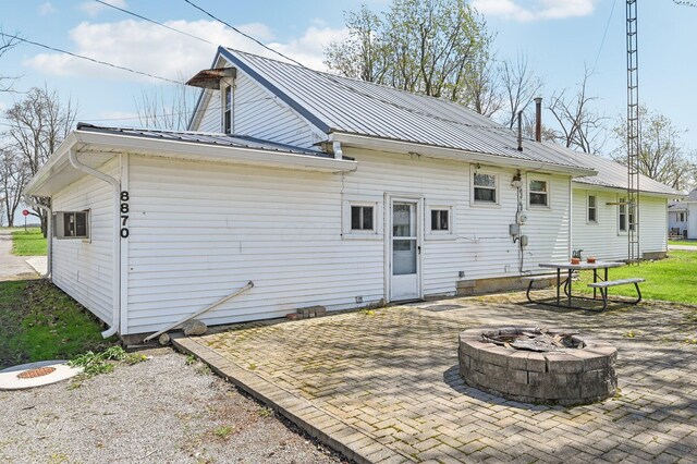 8870 College St, Lakeview, OH 43331 - rear view of property with metal roof, a patio, and an outdoor fire pit