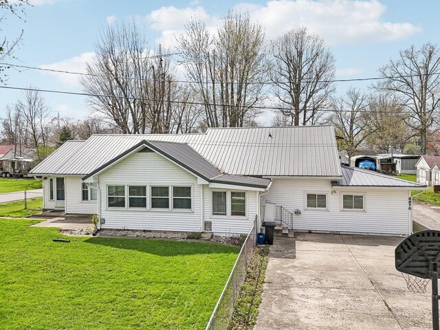 8870 College St, Lakeview, OH 43331 - rear view of house with driveway, metal roof, and a lawn