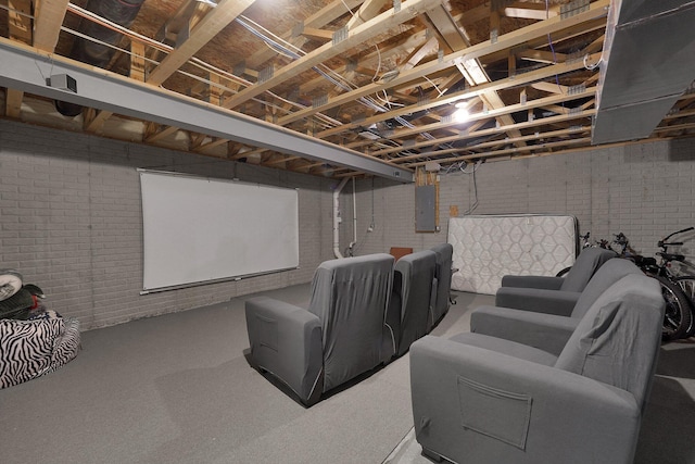 home theater room with electric panel and brick wall