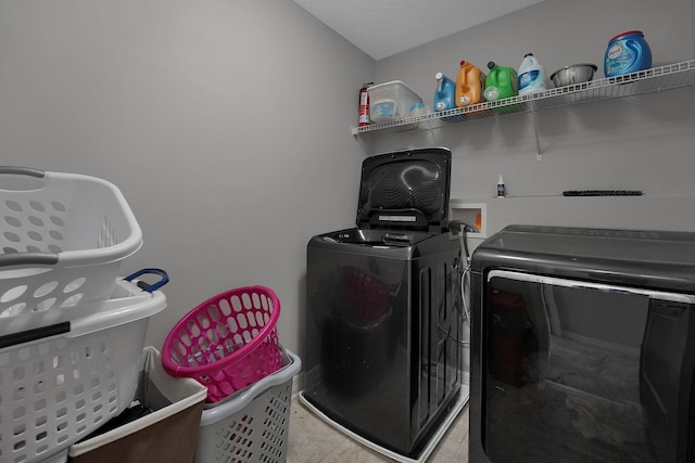 laundry room with independent washer and dryer, light tile patterned floors, and laundry area