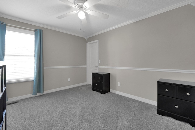 unfurnished bedroom with visible vents, baseboards, a ceiling fan, carpet floors, and ornamental molding
