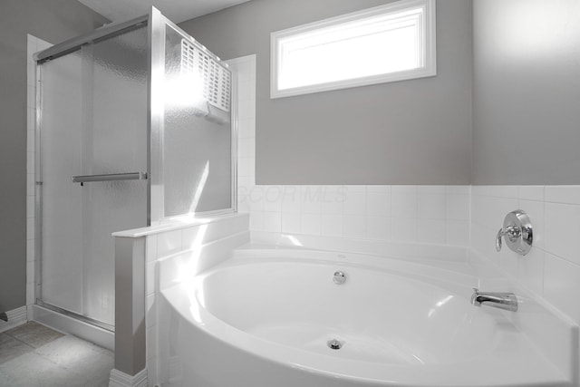 bathroom with a bath and a stall shower