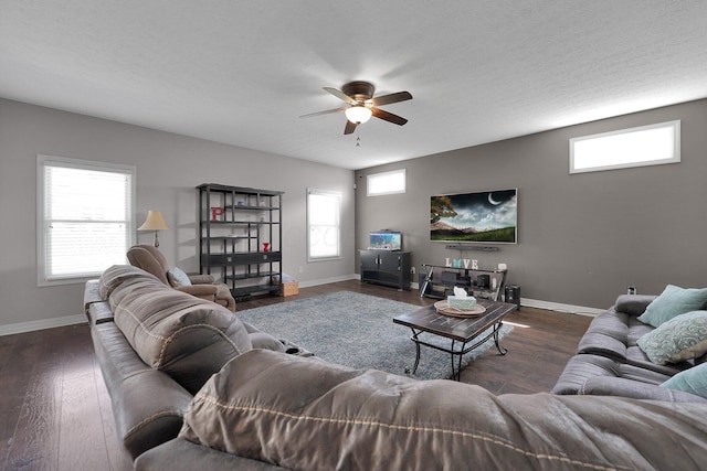 living room featuring a ceiling fan, baseboards, and dark wood-type flooring