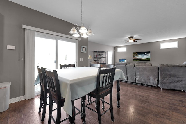 dining space with baseboards, a wealth of natural light, dark wood-style floors, and ceiling fan with notable chandelier