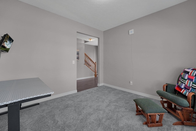 living area with baseboards, carpet floors, and stairs