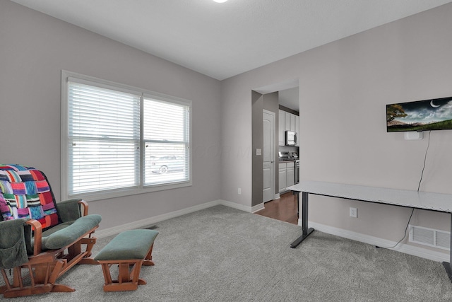 living area featuring visible vents, baseboards, and carpet flooring