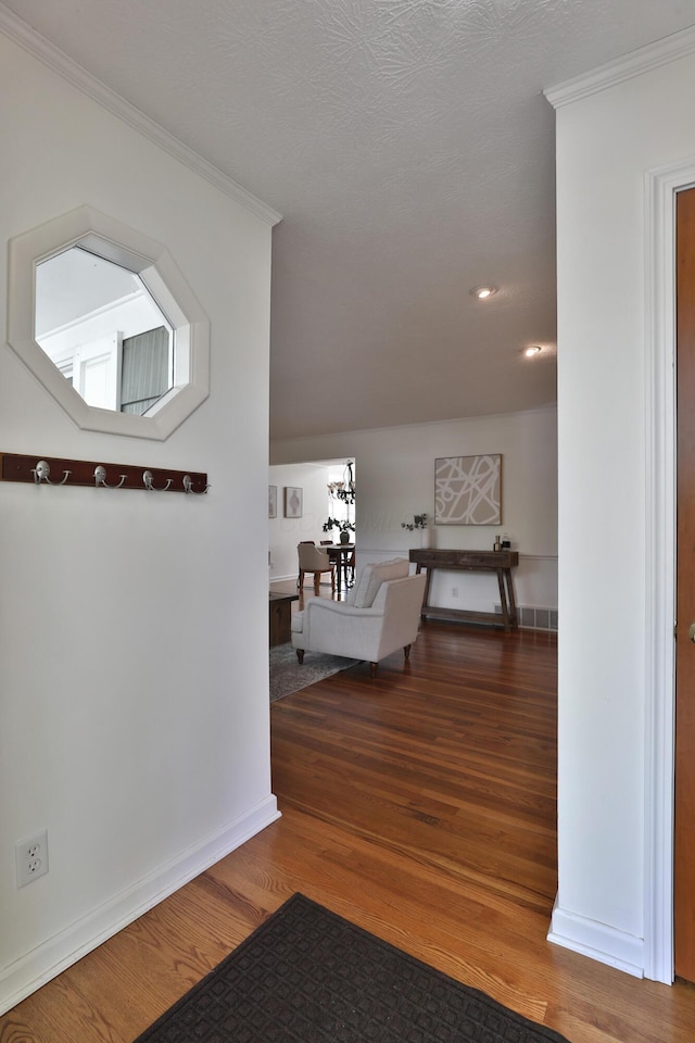 hallway with crown molding, recessed lighting, baseboards, and wood finished floors