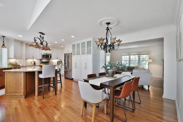 dining area with recessed lighting, a chandelier, ornamental molding, and light wood finished floors