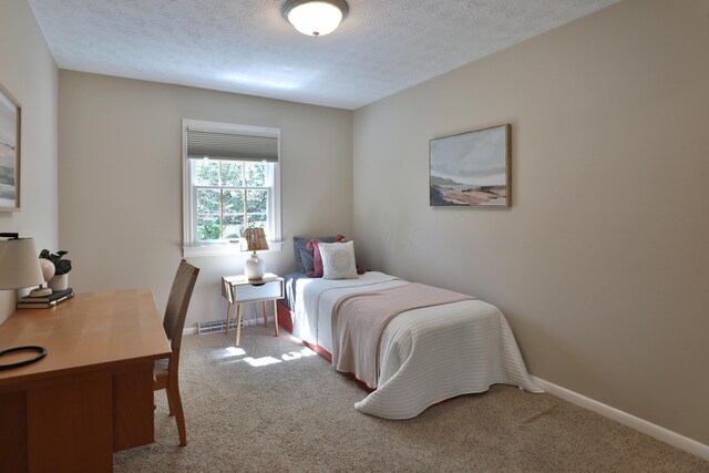 carpeted bedroom featuring baseboards, a textured ceiling, and visible vents