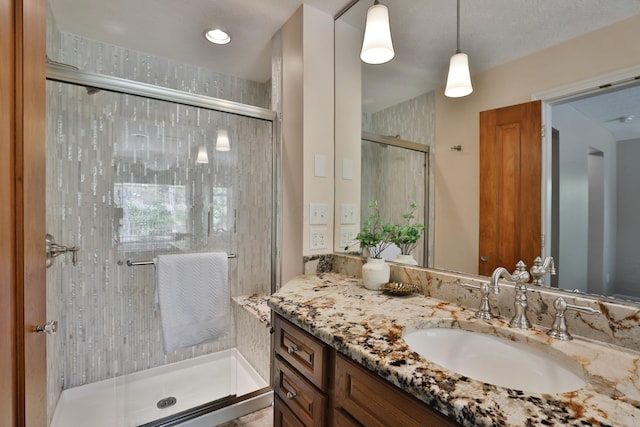full bathroom with vanity and a shower stall