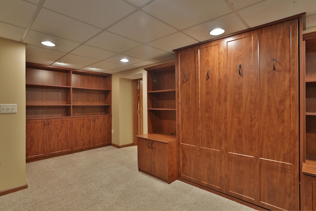 interior space featuring light carpet and a paneled ceiling