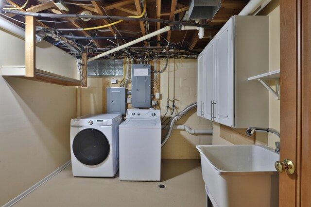 clothes washing area featuring a sink, electric panel, and washing machine and clothes dryer