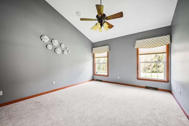 carpeted empty room featuring visible vents, a ceiling fan, vaulted ceiling, and baseboards