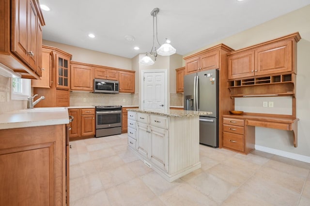 kitchen featuring a sink, stainless steel appliances, tasteful backsplash, a kitchen island, and pendant lighting
