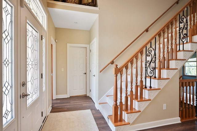 foyer entrance with baseboards, stairway, and wood finished floors