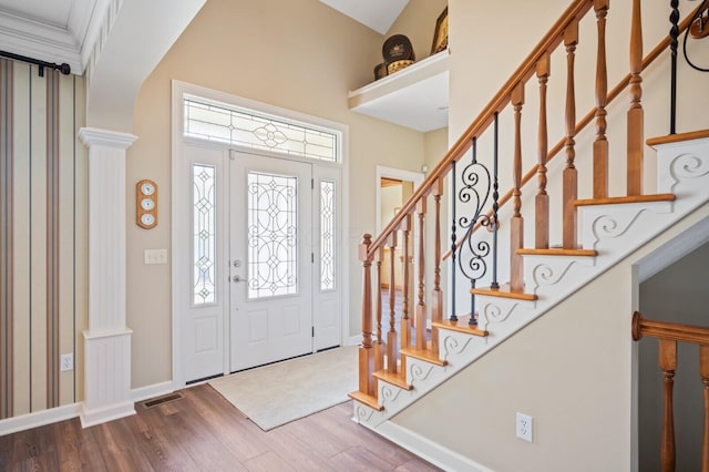 foyer entrance featuring wood finished floors, visible vents, stairs, and baseboards