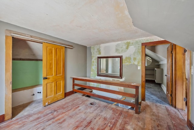 additional living space featuring baseboards and wood-type flooring