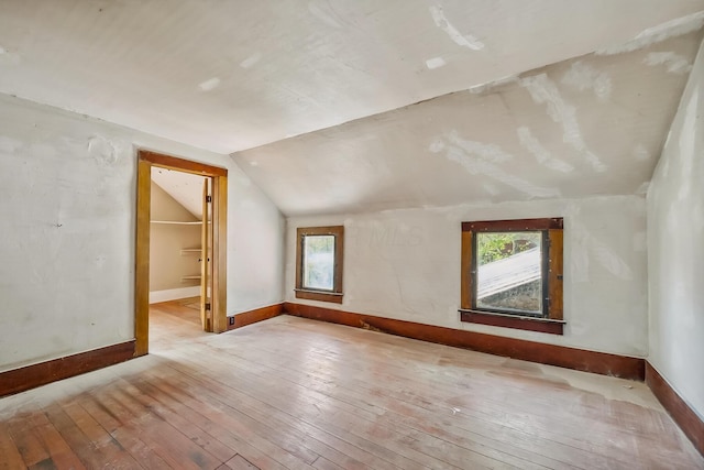 bonus room with hardwood / wood-style floors, baseboards, and vaulted ceiling