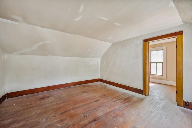 additional living space featuring baseboards, hardwood / wood-style flooring, and lofted ceiling