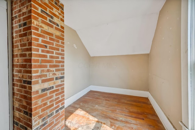bonus room with baseboards, hardwood / wood-style flooring, and lofted ceiling