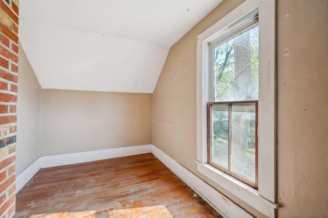 bonus room featuring hardwood / wood-style floors, baseboards, and vaulted ceiling