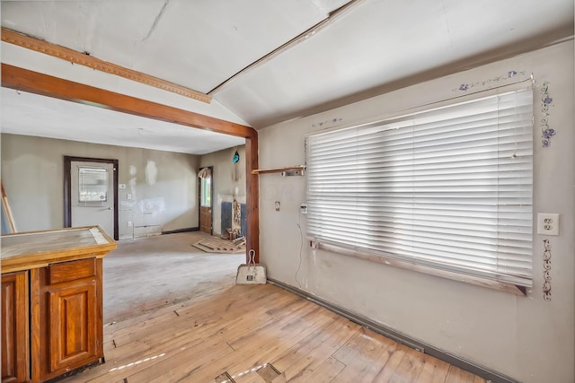 spare room featuring lofted ceiling and light wood-style floors